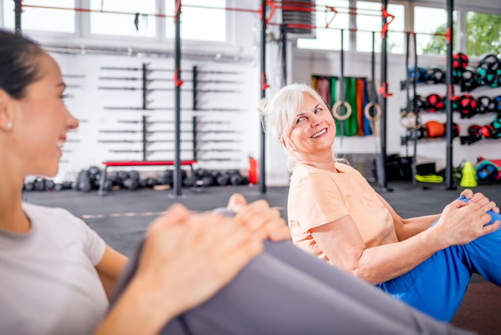 Senior woman workout with trainer at the gym