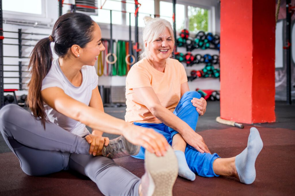 Senior woman workout with trainer at the gym